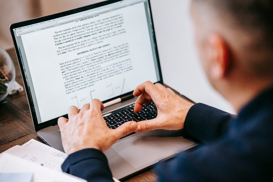 profesjonalista pracujący na laptopie z dokumentami przy biurku