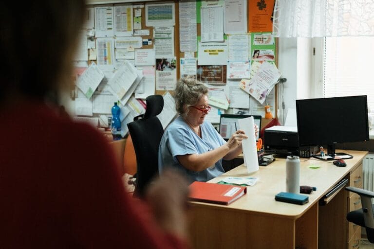 Specjalista medyczny analizujący i tłumaczący skomplikowaną dokumentację szpitalną w profesjonalnym biurze